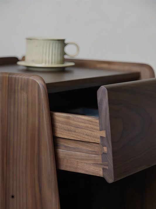 Cozy modern bedroom setup with Walnutry nightstand holding a coffee cup, showcasing warm wood tones.