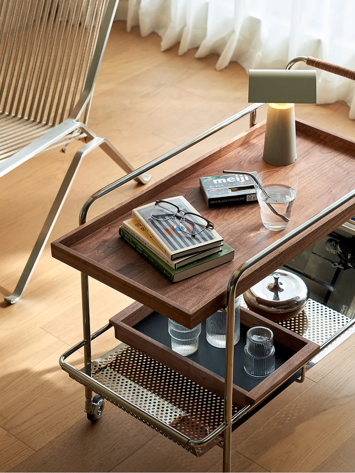 Walnutry Kurumi cart styled in a reading nook with books and glasses, showcasing its versatility as a side table.