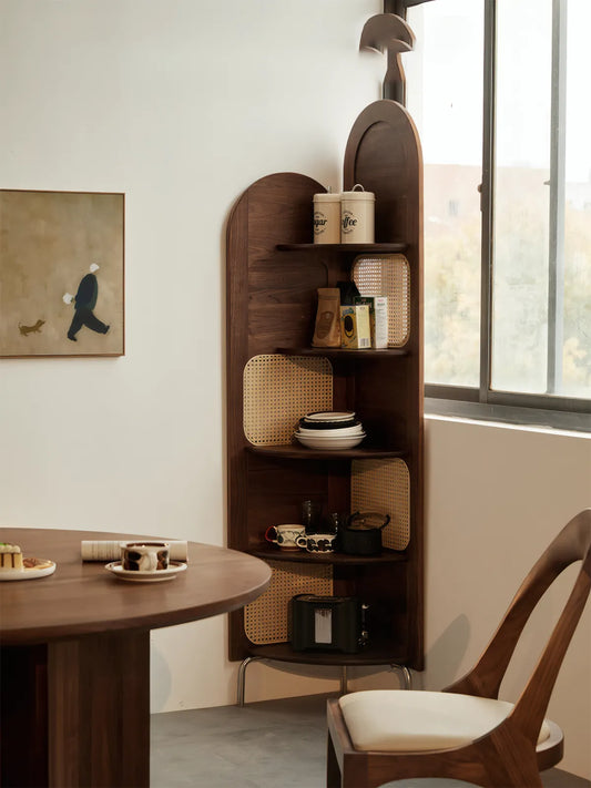 Elegant solid walnut corner display cabinet from Heritage collection placed in a dining room with rattan accents and coffee set.
