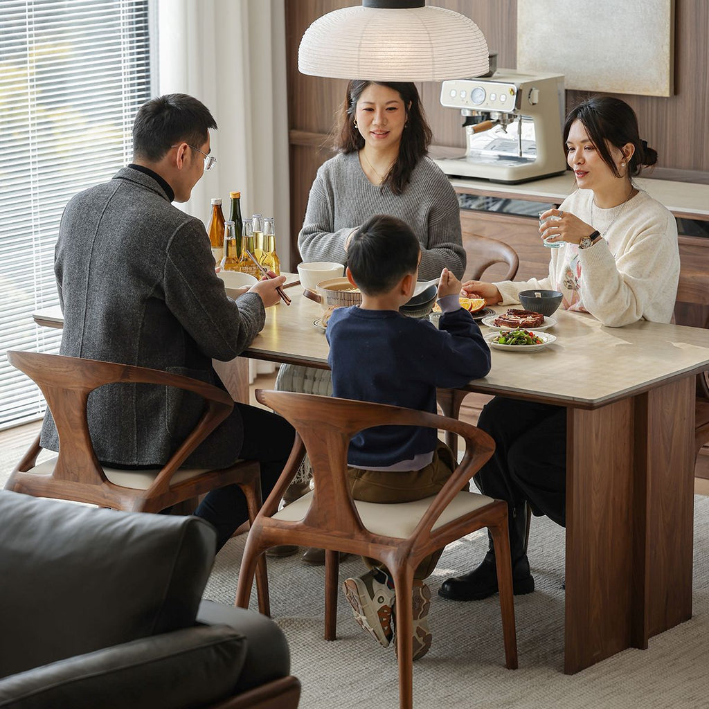 Mid-century modern dining room with wooden armchairs and family enjoying meal together