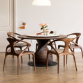 Mid-century modern dining room with round wooden table and four sculptural wood armchairs