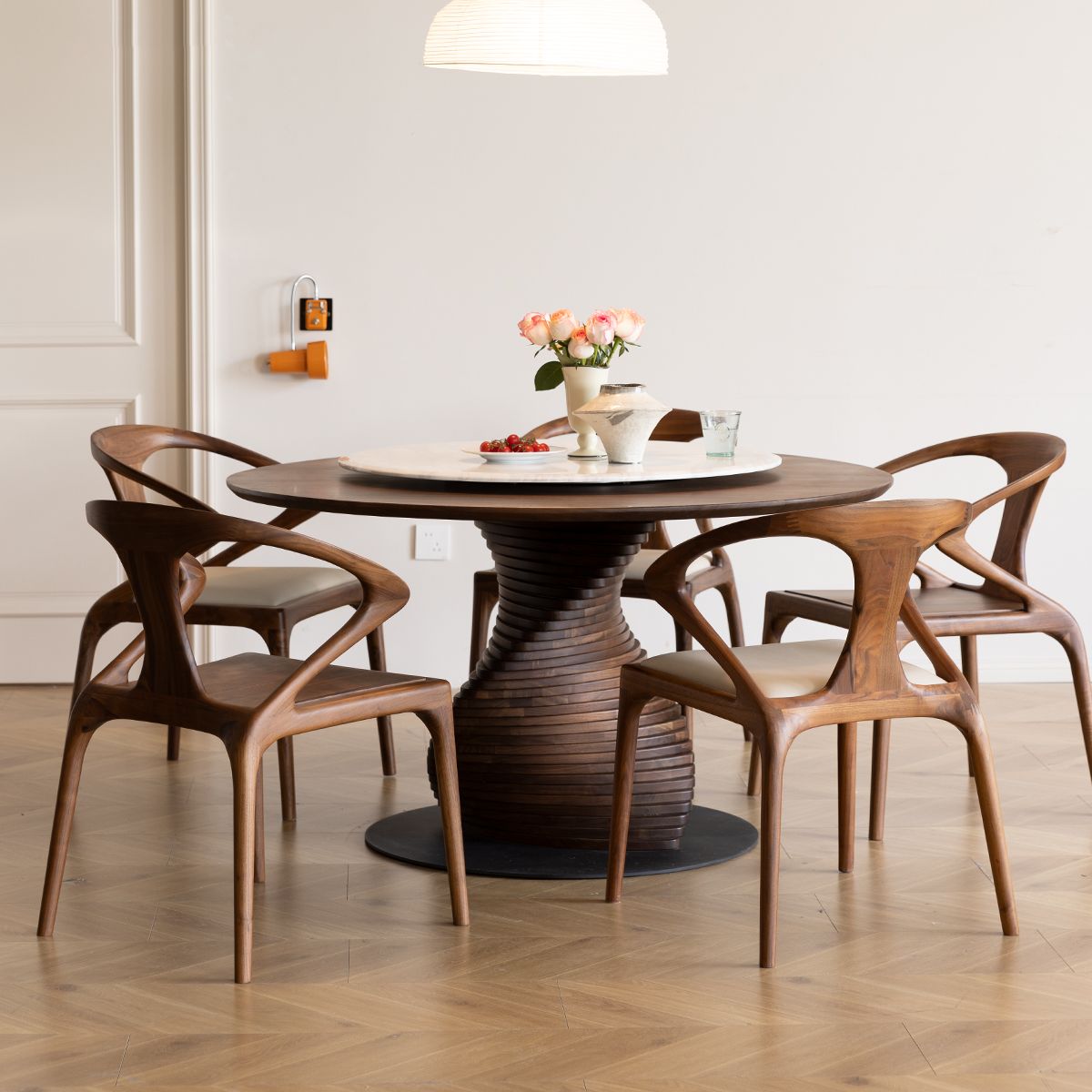 Mid-century modern dining room with round wooden table and four sculptural wood armchairs