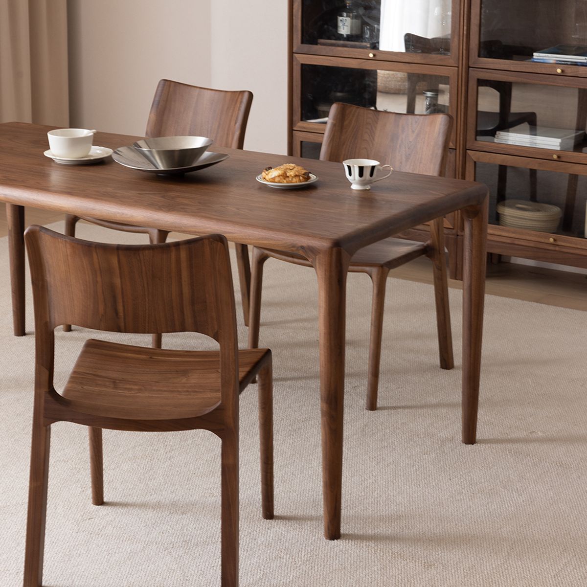 Modern dining room featuring a set of contour solid walnut chairs around a table.
