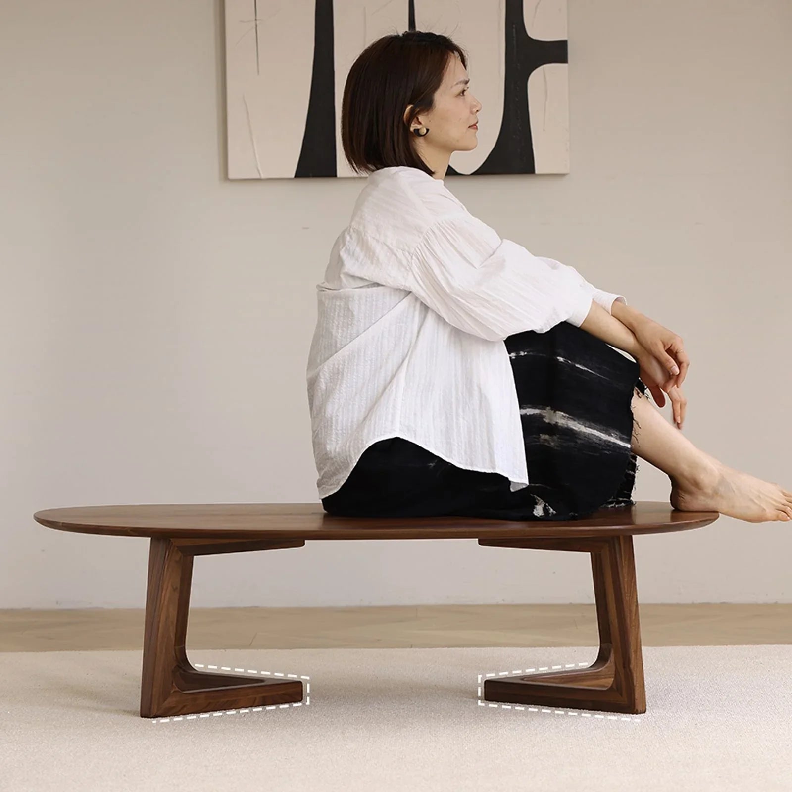Mid-century modern solid black walnut coffee table with unique angled legs in minimalist living room