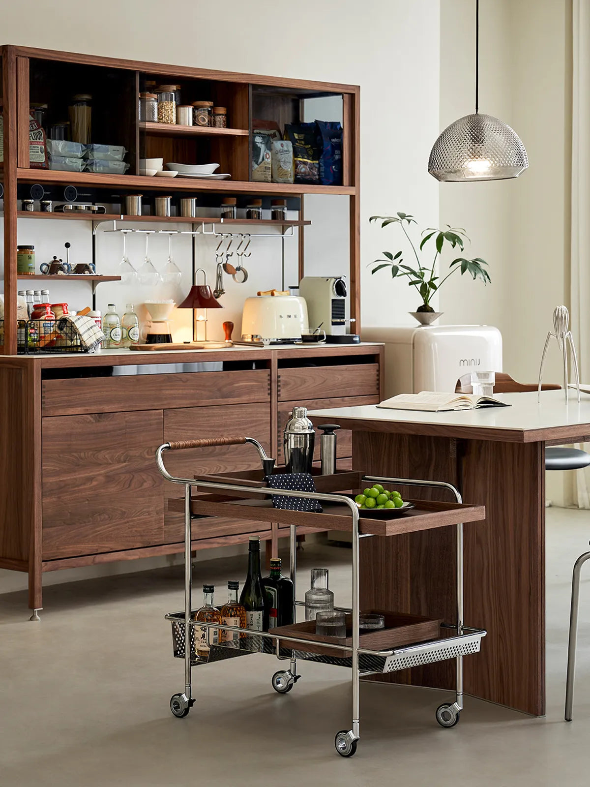 Kurumi serving trolley in a modern kitchen setting, displaying solid walnut shelves and pantry storage capacity.