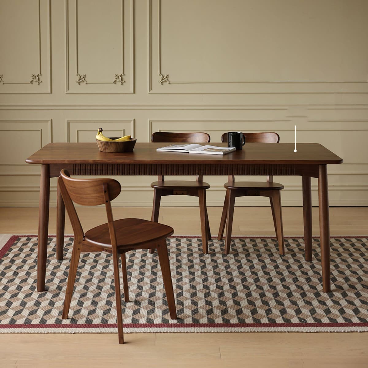 Front view of the Sylva walnut chair placed in a minimalist room with warm lighting, highlighting the tapered legs.