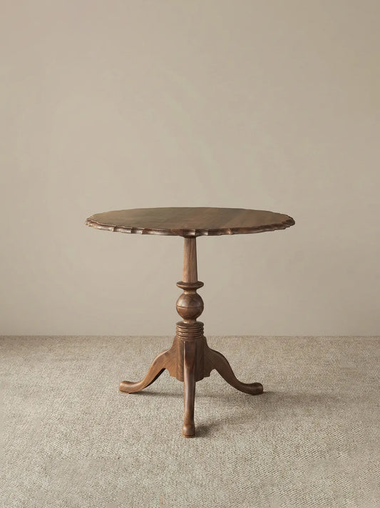 Studio shot of the Margaux table on a neutral background highlighting the silhouette and scallop details.