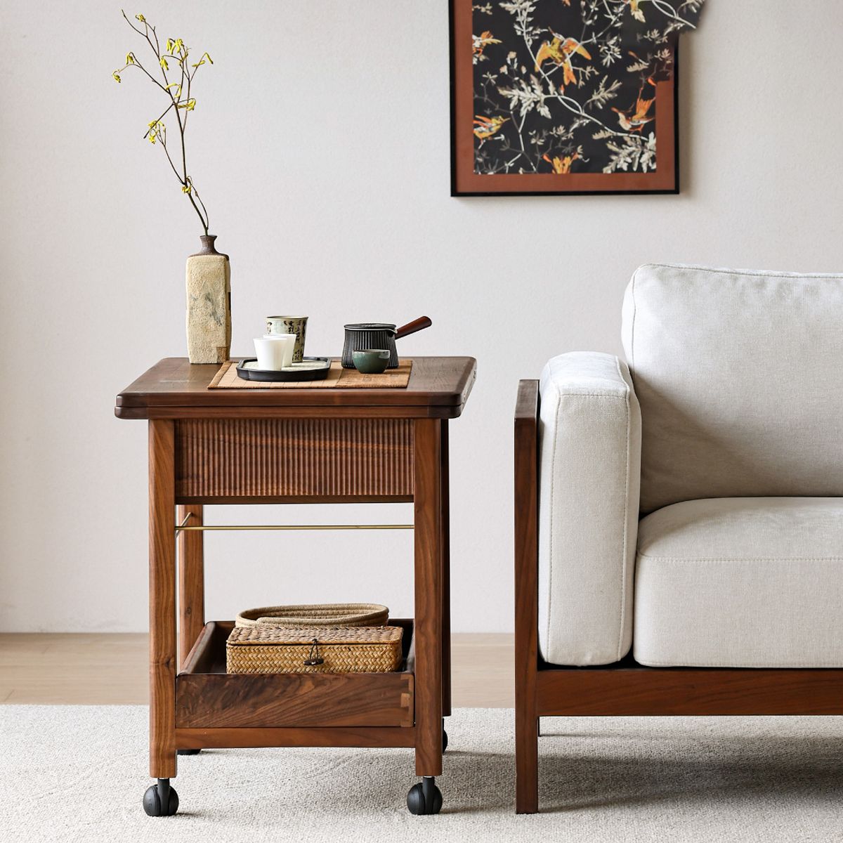 Walnutry Nomad mobile solid walnut side table being used as a laptop desk next to a sofa.