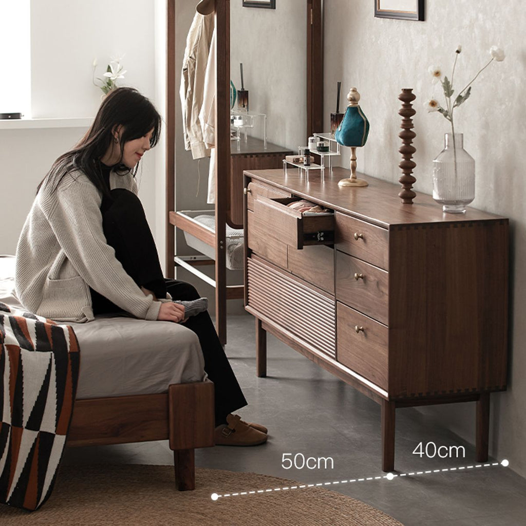 Walnutry Grid 8-drawer solid black walnut dresser with a person in a bedroom