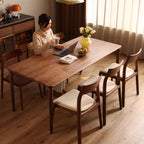 Modern dining room setting featuring a set of comfortable white leather and walnut chairs with a person.