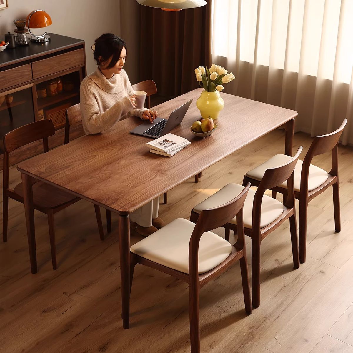 Modern dining room setting featuring a set of comfortable white leather and walnut chairs with a person.