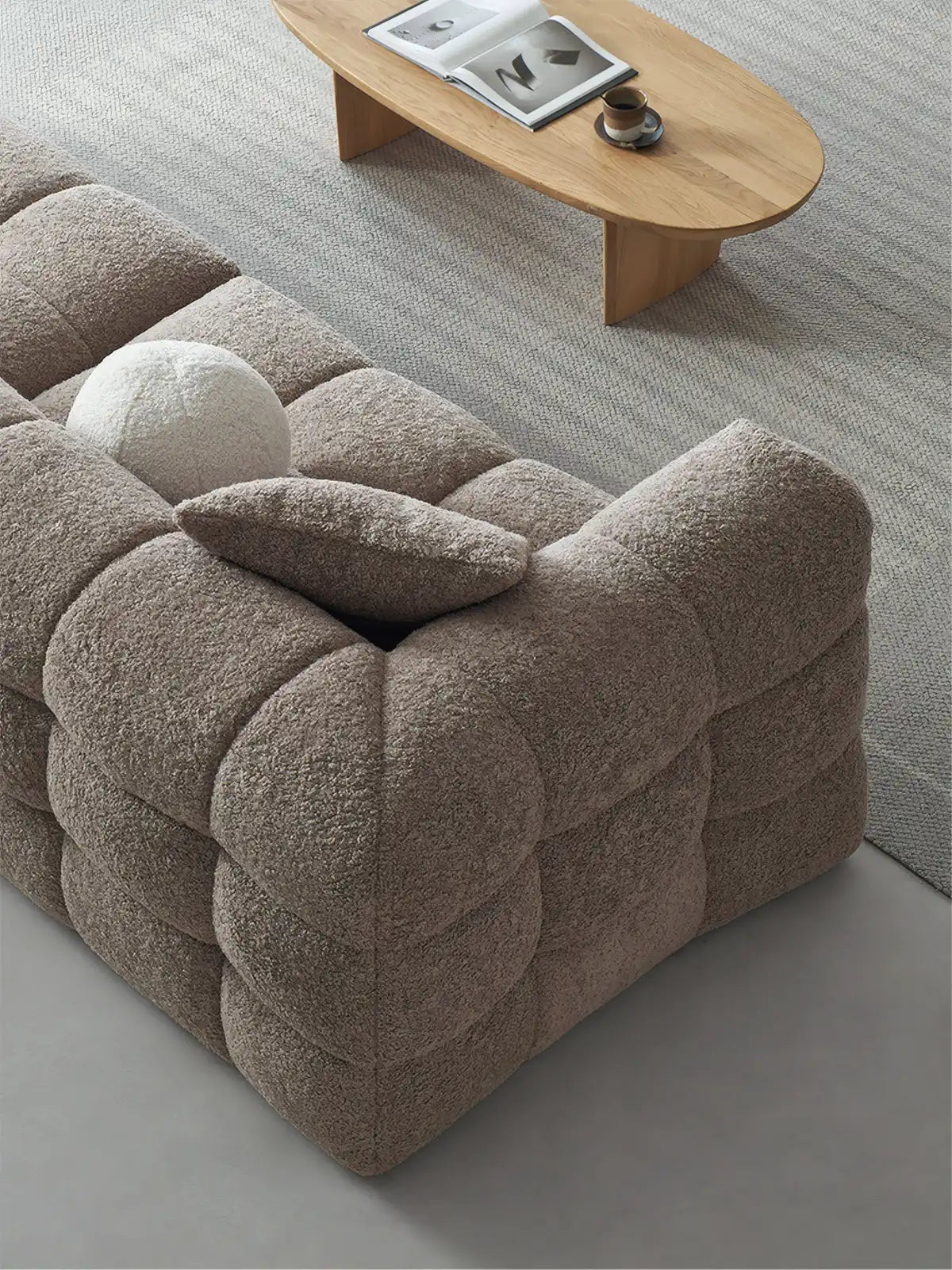 High angle view of the Cumberland sectional showing the deep biscuit tufting pattern and textured white bouclé fabric.