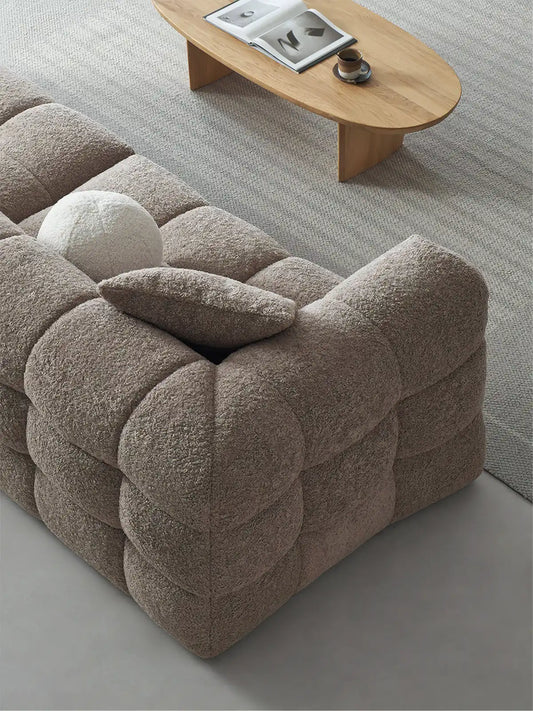 High angle view of the Cumberland sectional showing the deep biscuit tufting pattern and textured white bouclé fabric.