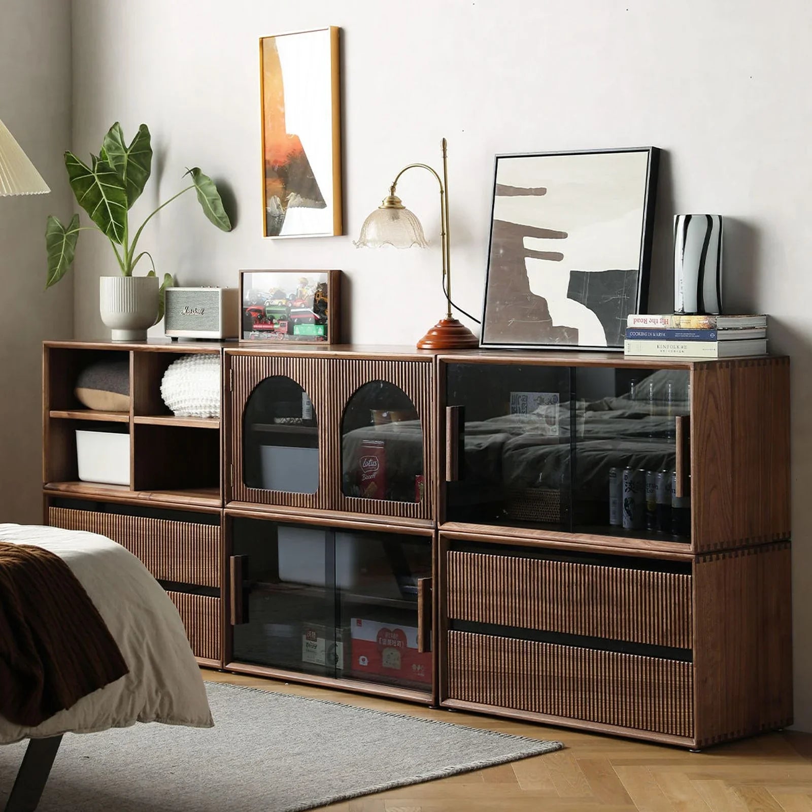 Modular walnut storage system with glass doors, open shelves, decor items in contemporary bedroom