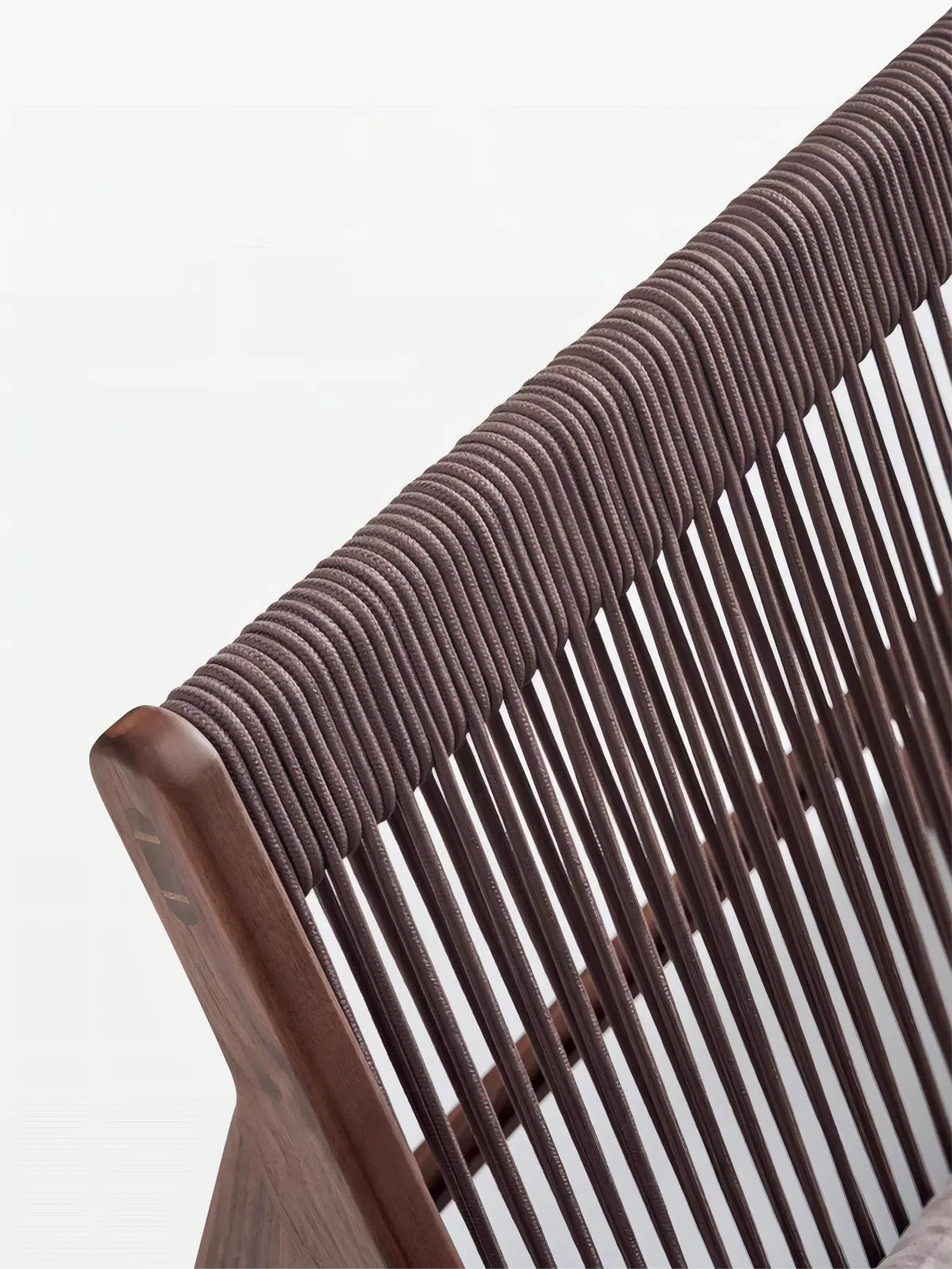 Macro shot of North American Black Walnut wood grain on the top rail of the chair with rope details.