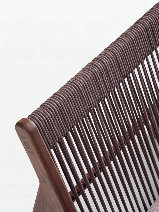 Macro shot of North American Black Walnut wood grain on the top rail of the chair with rope details.