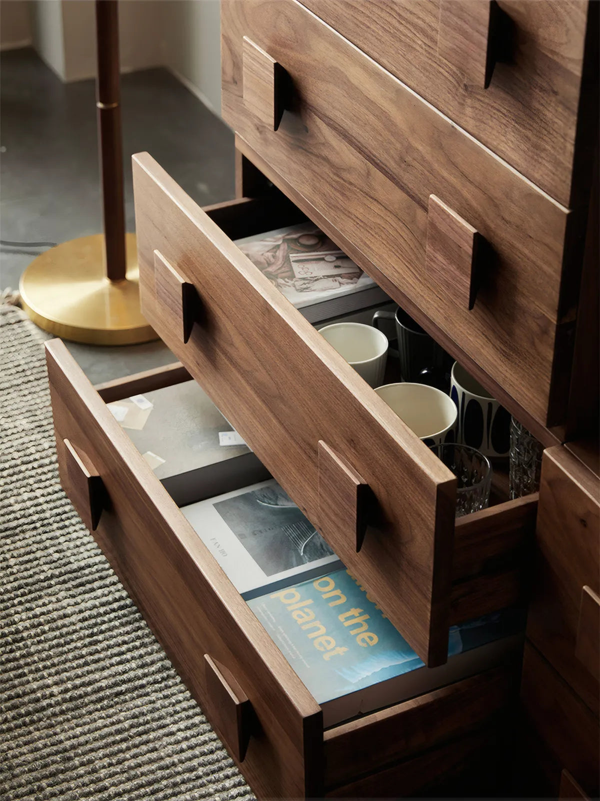 Open drawer of Walnutry unit revealing solid wood construction, dovetail joinery, and ample storage space for books and mugs.