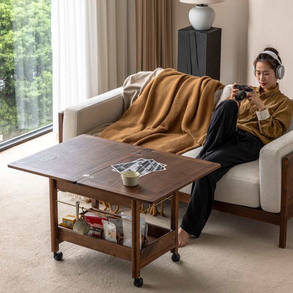 Modern wooden storage cart with foldable table top and snacks underneath in cozy living room