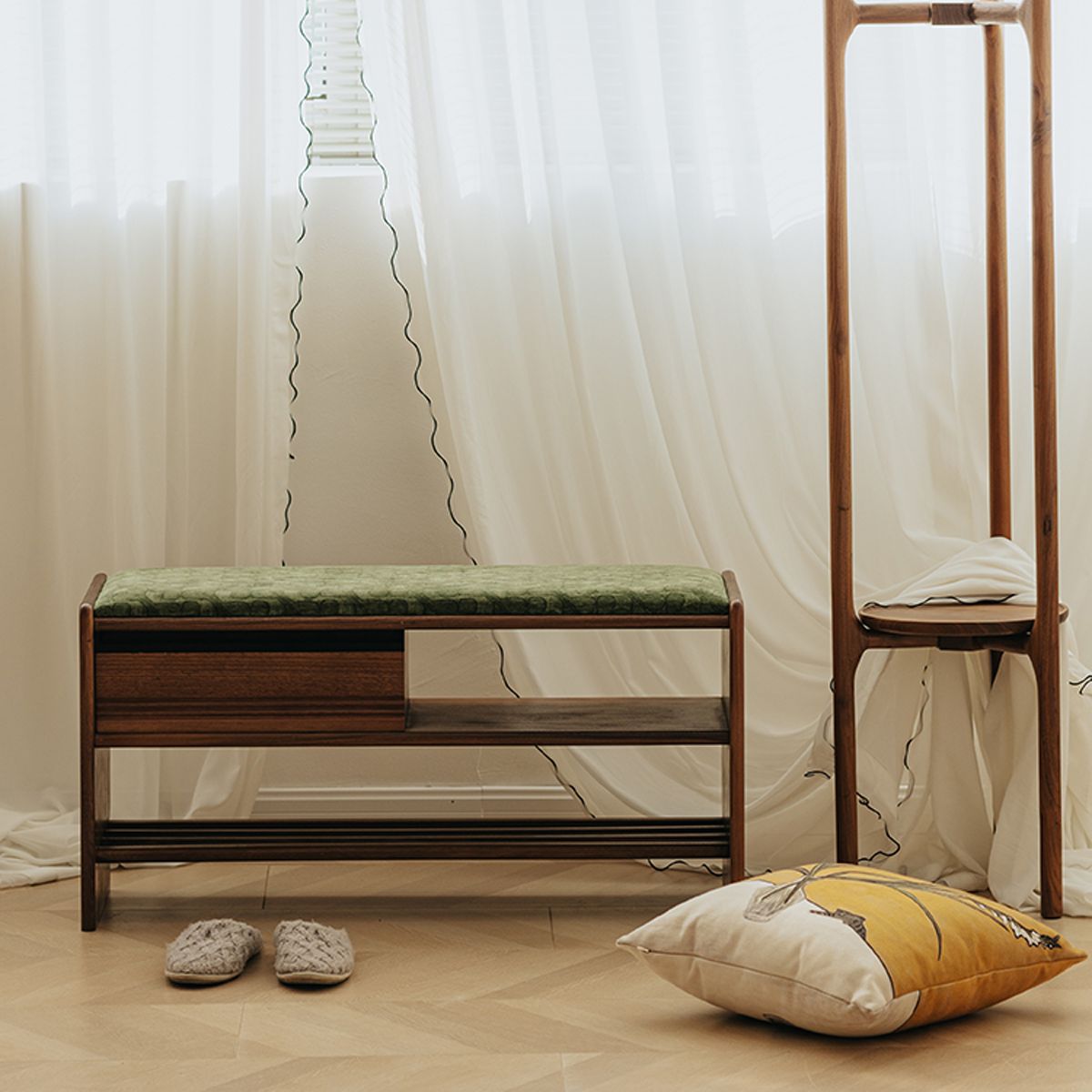 Heirloom walnut wood shoe bench with green cushion, slippers, standing mirror, and decorative pillow