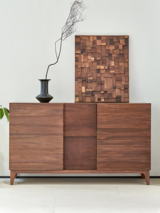 The Opus 60-inch mid-century modern credenza in solid walnut, decorated with wooden wall art and a black minimalist vase.