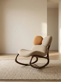 Side profile of The Cairn Rocker in Sandstone beige, showing the fluid wooden curves and ergonomic recline angle.