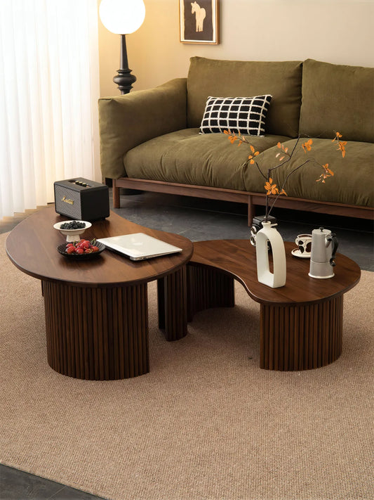 "Top angle view of irregular cloud shaped walnut tables nesting together, displaying natural wood grain."