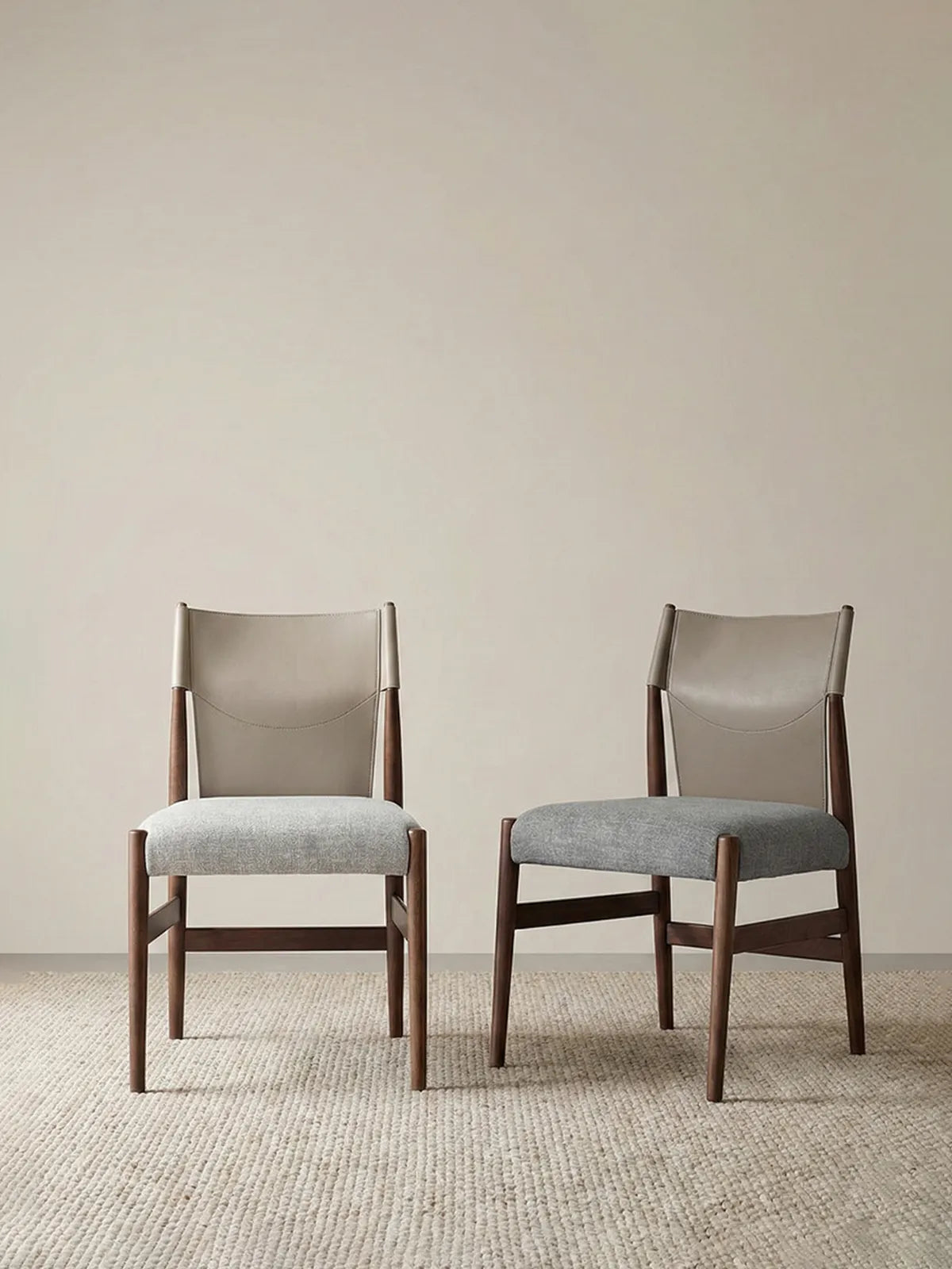 A pair of Walnutry Opus chairs placed in a minimalist interior, demonstrating their versatility as both dining seating and accent chairs.