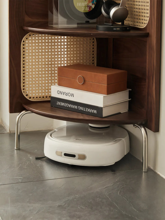Bottom detail of Heritage walnut corner shelf showing raised metal legs allowing robot vacuum clearance and storage for marketing books.