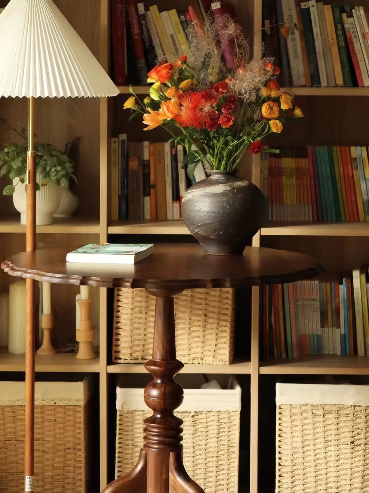 The Margaux table used as a library side table with a vase of flowers, styled against a bookshelf.
