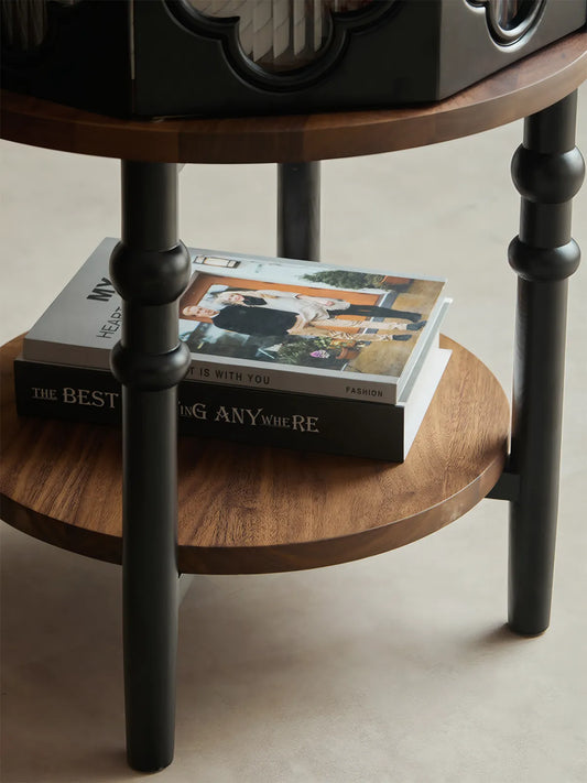 Bottom open shelf of Sylvan walnut nightstand holding stacked fashion books.
