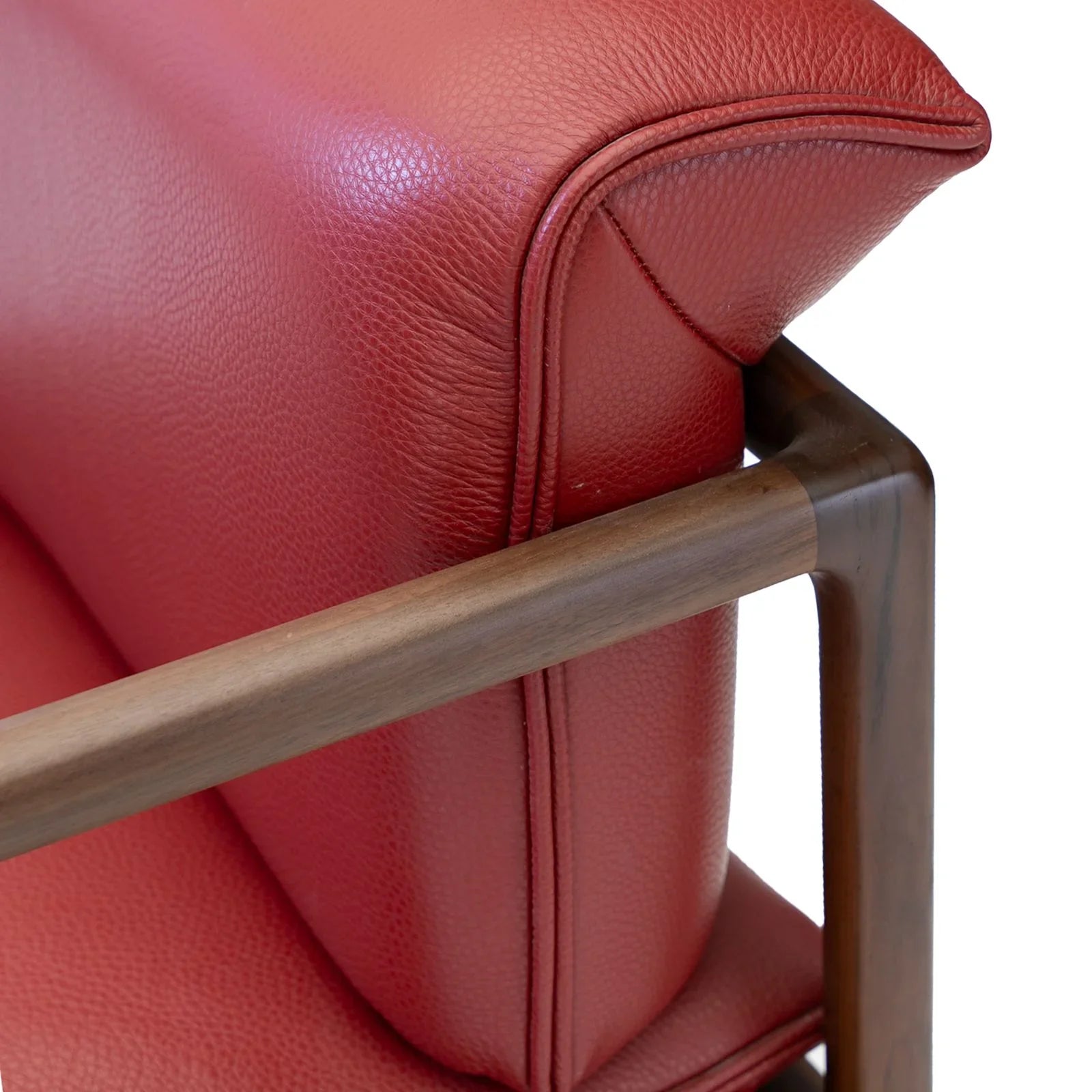 Detail showing the smooth, rounded solid walnut wood frame construction of the modern chair.