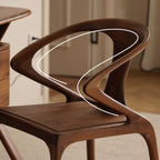 Side profile of the Danish modern walnut chair showing the continuous fluid line of the armrest.