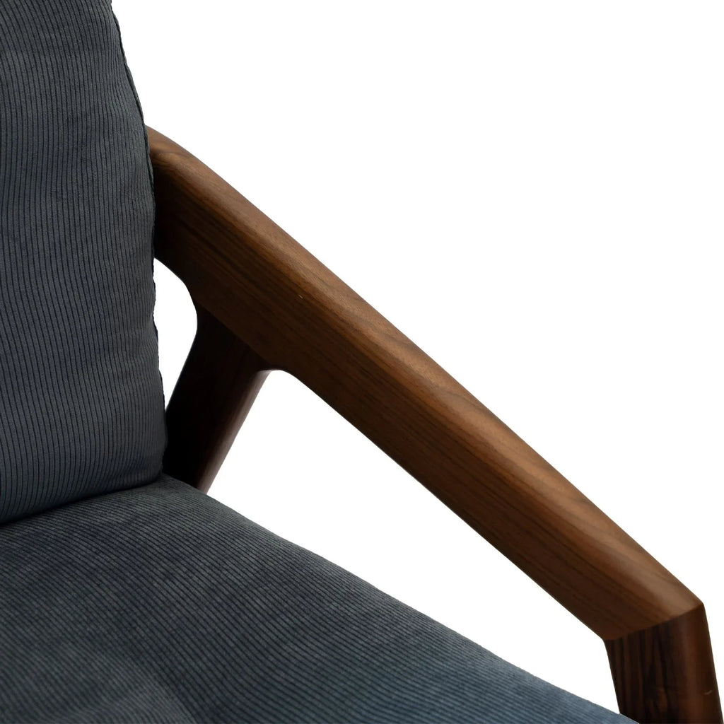 Close-up of Walnutry solid black walnut lounge chair armrest with dark gray fabric upholstery