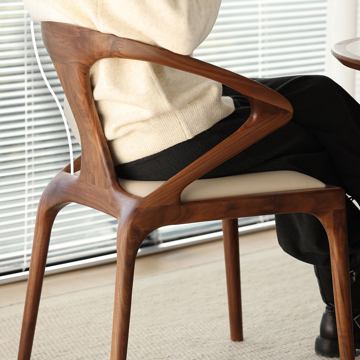 Solid walnut chair with unique geometric backrest and beige cushioned seat in indoor setting