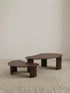 "Studio isolation shot of the Walnutry Kurumi solid wood nesting table set on a neutral background."