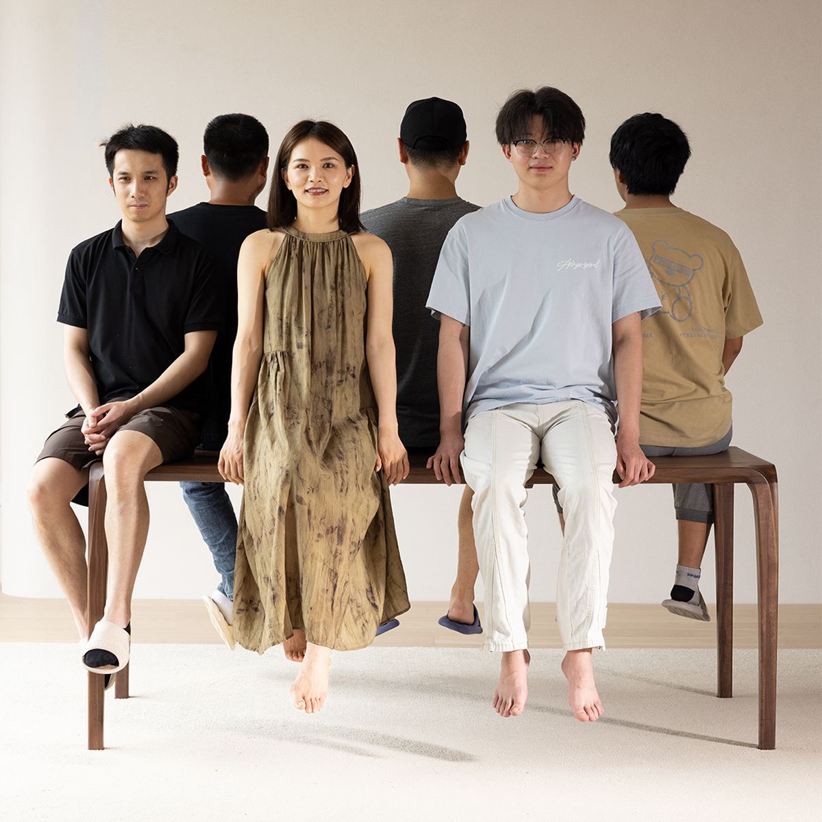 Solid walnut dining table by WALNUTRY WOOD with people sitting and standing around it in modern setting