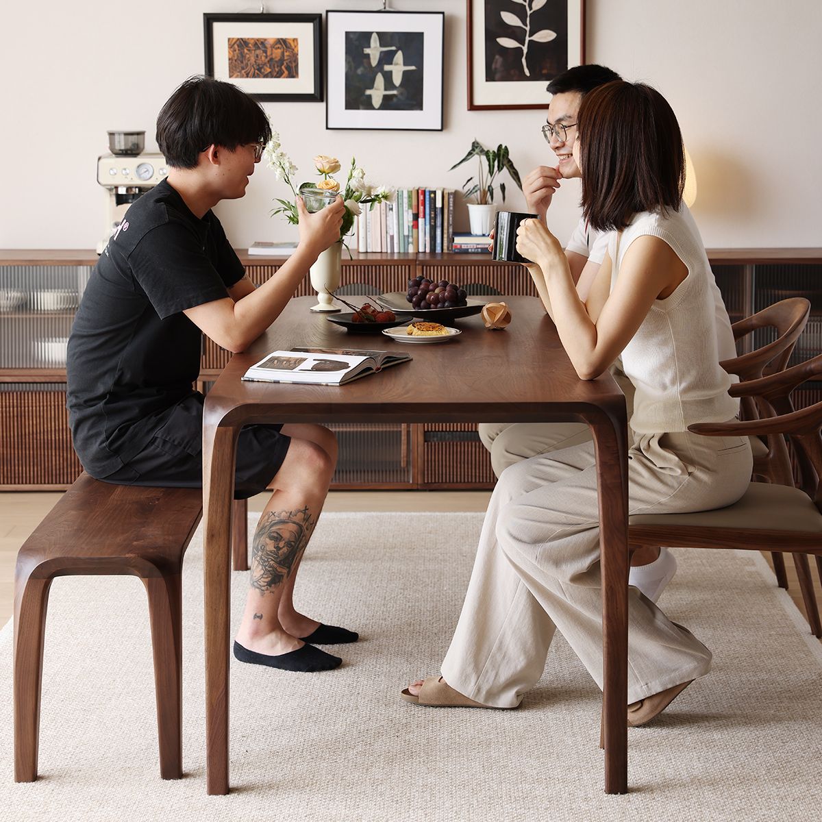 Three people seated around WALNUTRY WOOD solid walnut dining table enjoying casual meal in modern dining room