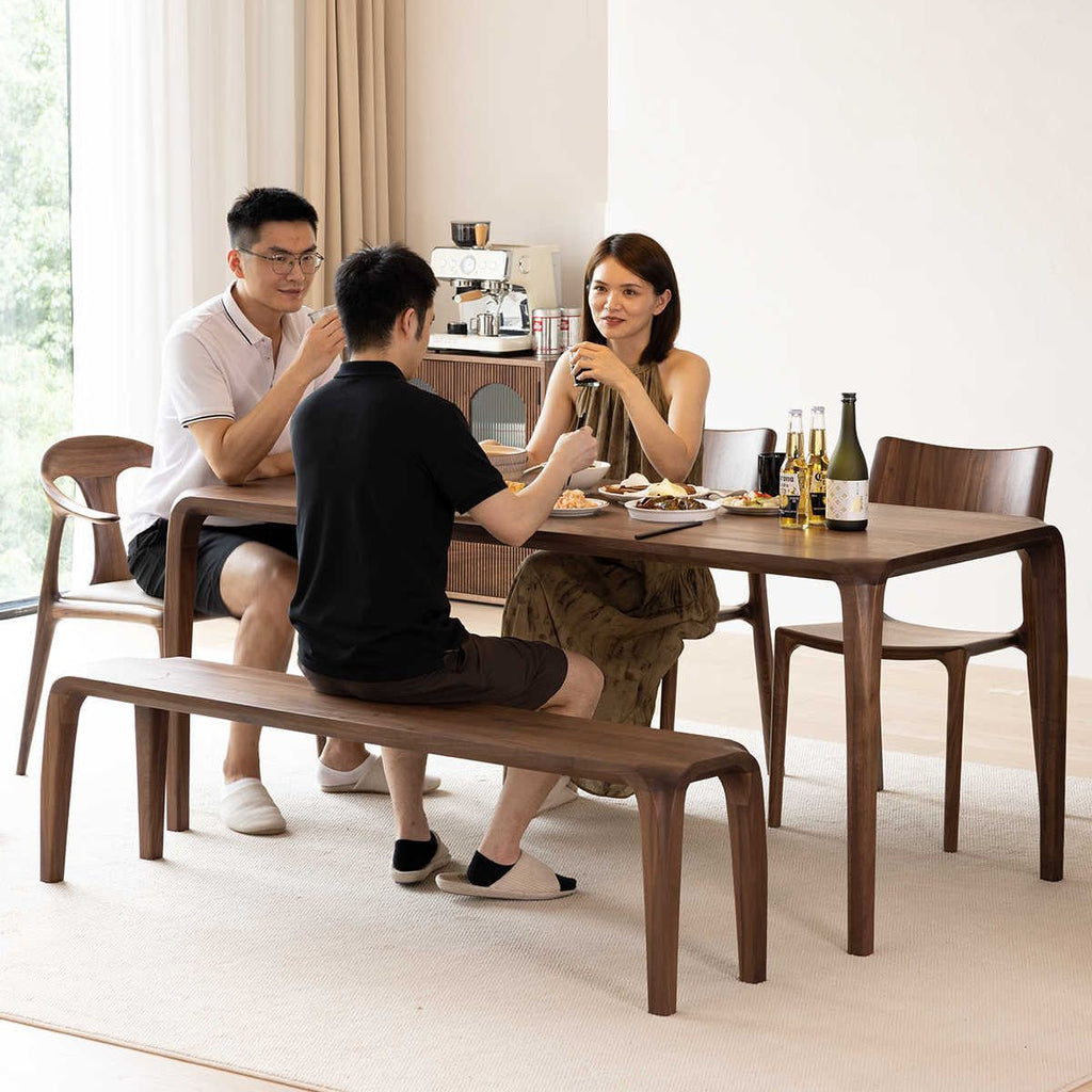 WALNUTRY WOOD solid walnut dining table with matching chairs and bench in modern dining room setting