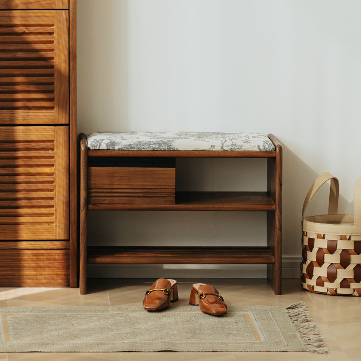 Solid walnut entryway bench with cushioned top and shoe storage, paired with stylish brown heels and basket