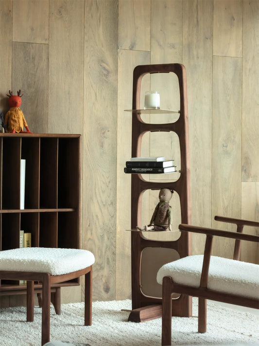 Side profile of the walnut shelving unit showcasing the premium solid wood grain, joinery details, and matte oil finish against a wood-paneled wall.