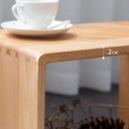 Close-up of smooth rounded edge 2cm thick solid wood table with white teacup and saucer