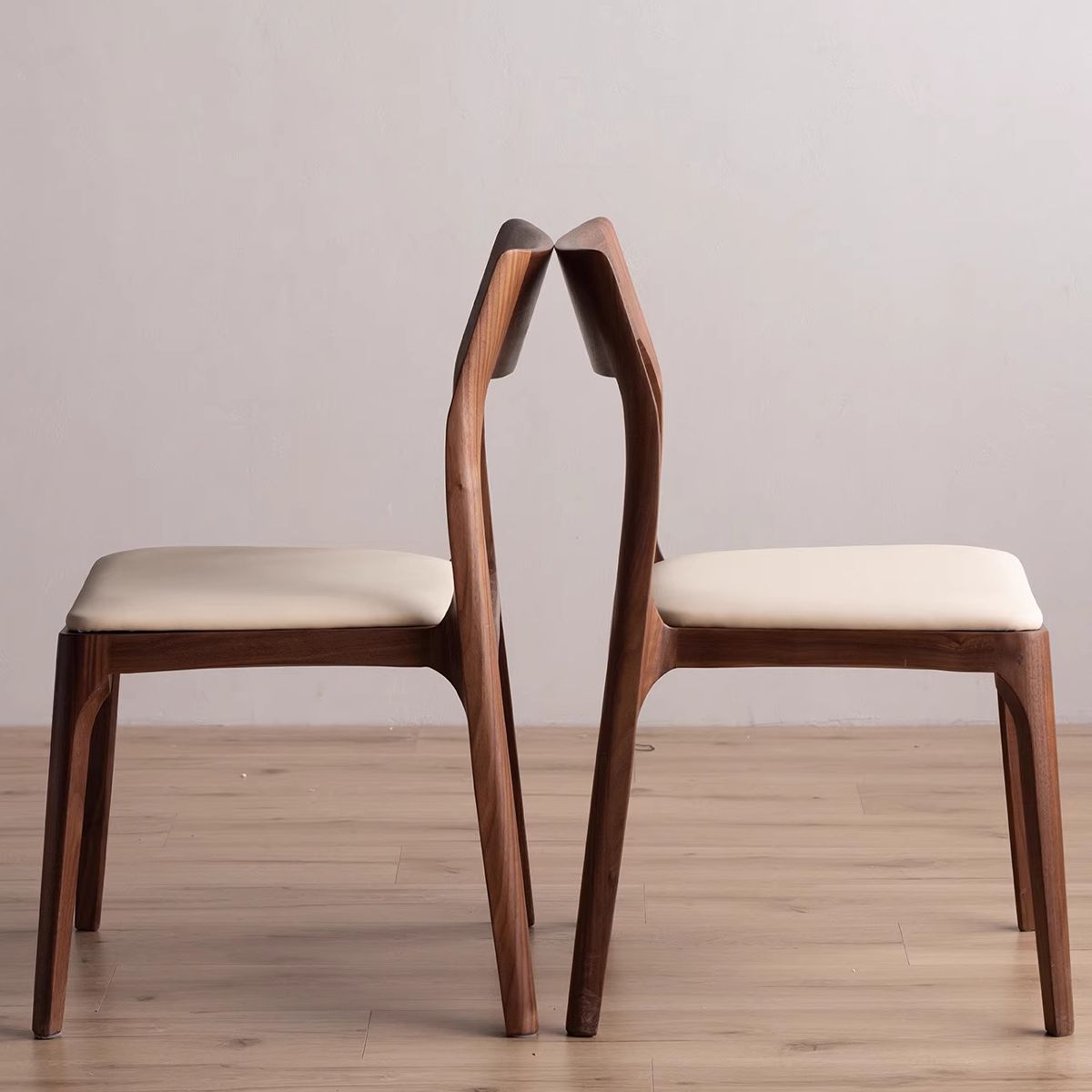 Side profile of the upholstered dining chair showing the sturdy solid walnut wood frame.