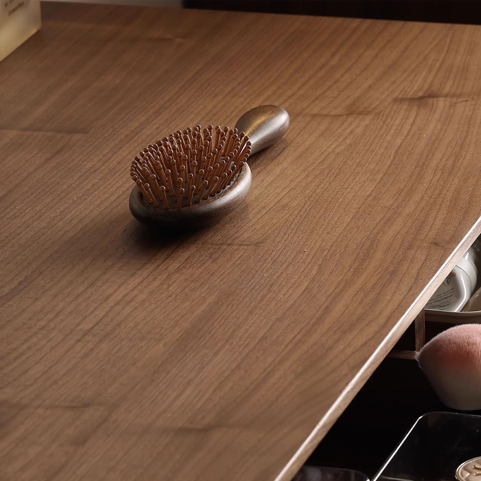 Solid wood makeup table top with a wooden hairbrush and visible makeup items in drawer