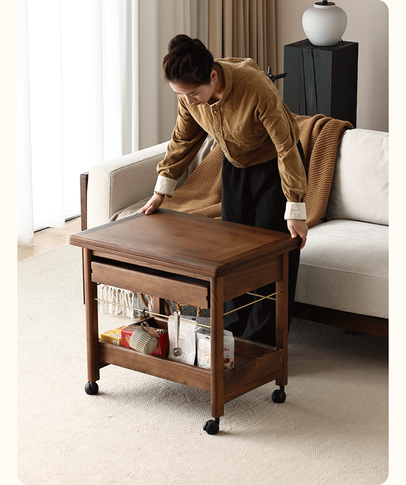 Person adjusting solid wood rolling cart side table with storage shelf in bright living room