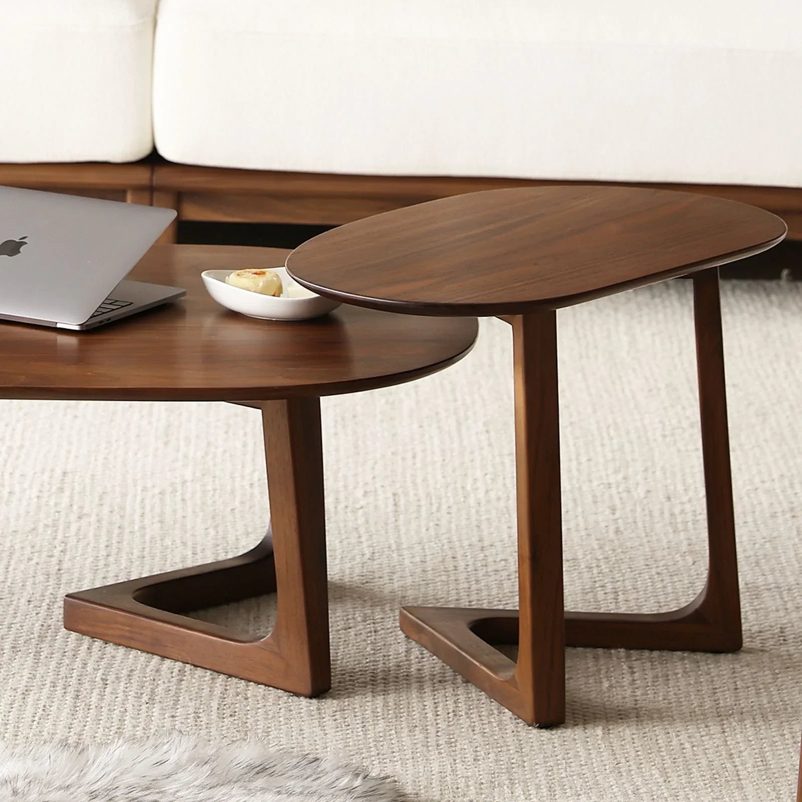Two solid walnut coffee tables with tapered legs on beige textured rug, modern living room setup