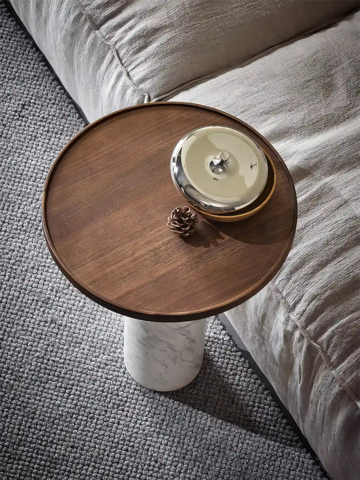 Lifestyle shot of a mid-century modern martini table holding a silver tray and pinecone decor.