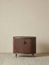 Front view of the Suiseki Oval Nightstand made of North American black walnut, featuring a continuous vertical slat design and tapered legs.