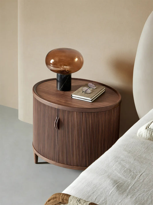 High-angle view of the oval-shaped Suiseki Nightstand, highlighting the raised tabletop edge and spacious surface for bedside essentials.