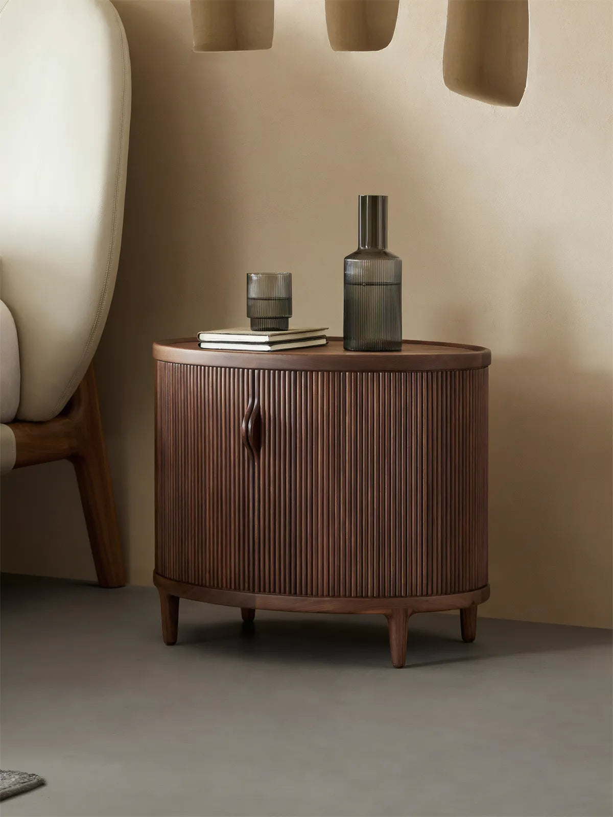 Side profile of the Suiseki Oval Nightstand, showing the elegant curved silhouette and dark walnut tones suitable for modern interiors.