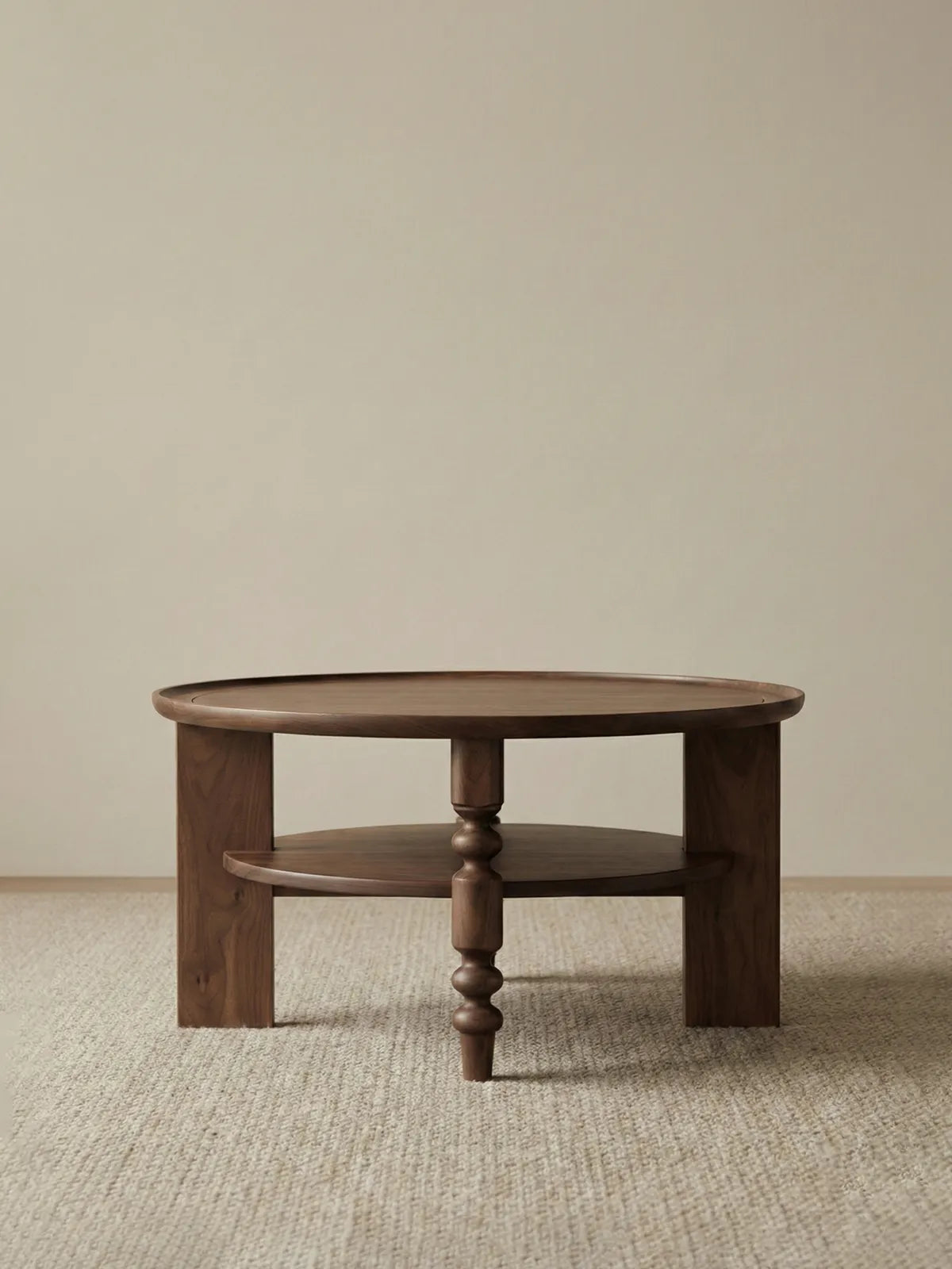 Isolated front view of the Walnutry Sylvan solid black walnut round coffee table with storage shelf on white background.